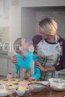 Mother and daughter having fun while preparing cookies in kitchen
