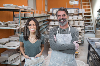 Male and female potter standing in pottery workshop