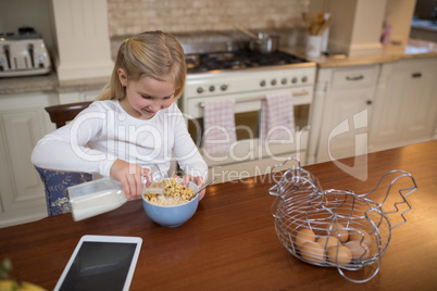 Young girl having breakfast in the kitchen at home