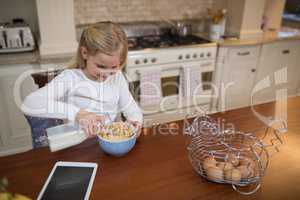 Young girl having breakfast in the kitchen at home
