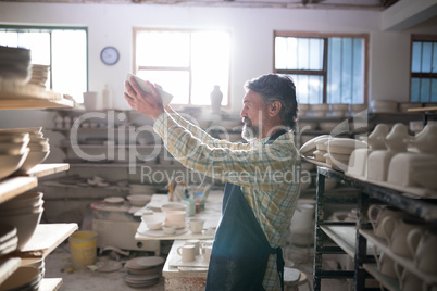 Male potter checking bowl