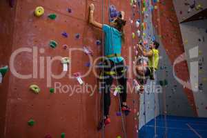 Dedicated athletes climbing wall in club