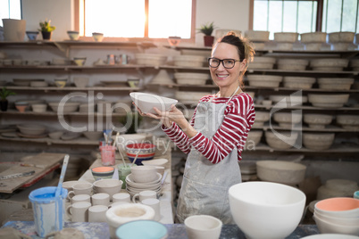 Portrait of female potter holding bowl