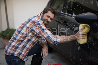 Man washing a car on a sunny day