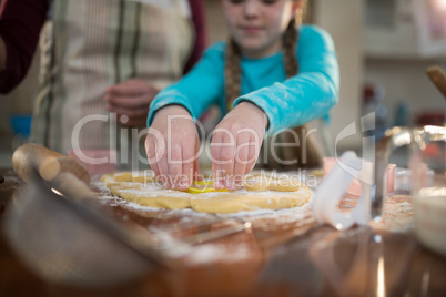 Mother and daughter preparing cookies in kitchen