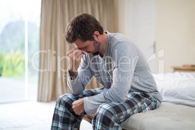 Stressed man sitting on the bed