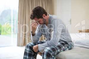 Stressed man sitting on the bed