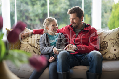 Father and daughter using digital tablet