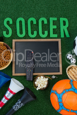 Chalkboard, snacks and football on artificial grass