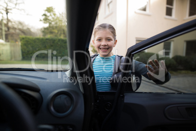 Teenage girl washing a car on a sunny day