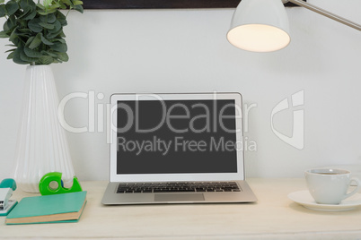 Laptop and various office accessories on table