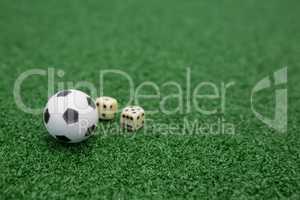 Football and dices on artificial grass