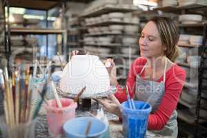 Female potter decorating bowl
