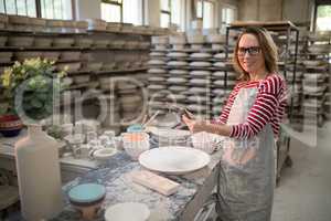 Portrait of female potter using digital tablet