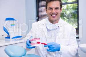 Portrait of dentist brushing dental mold