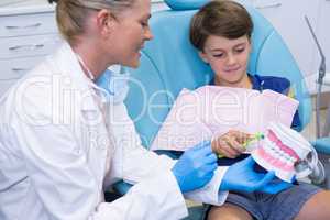 Doctor teaching boy brushing teeth