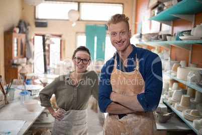 Male and female potter standing in pottery workshop