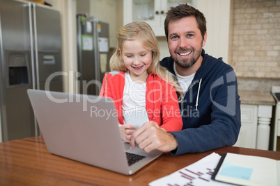 Father and daughter working on laptop