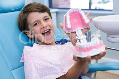 Portrait of cute boy holding dental mold