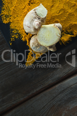 Turmeric powder and ginger on board