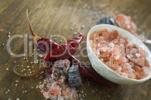 Himalayan salt with spices on wooden table