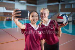 Smiling female players taking selfie with mobile phone