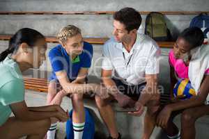 Volleyball coach talking to female players