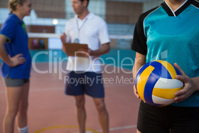 Volleyball player holding ball in court