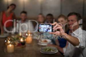 Happy friends taking selfie with mobile phone