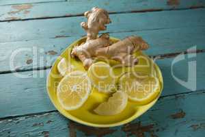 Lemon slices and ginger in yellow plate
