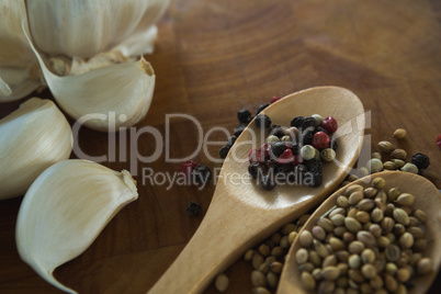 Garlic bulbs and spices on wooden board