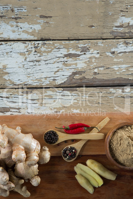 Directly above view of spices on serving board over weathered table