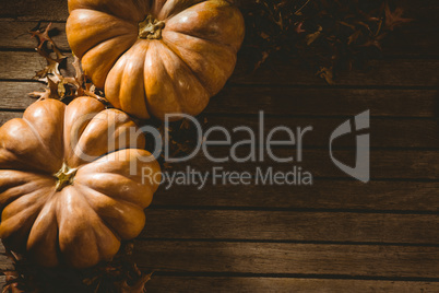 Orange pumpkins with autumn leaves on table