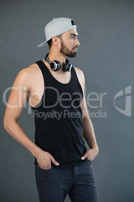 Man posing with hands in pocket against grey background