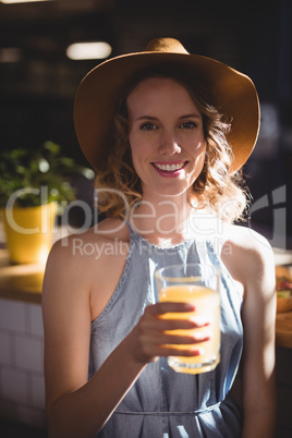 Portrait of smiling young woman holding fresh juice glass