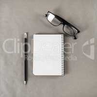 Blank notebook, glasses, pencil