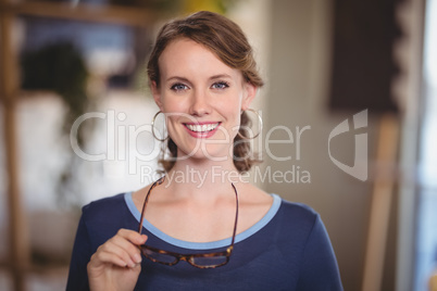 Close up portrait of smiling young waitress holding eyeglasses