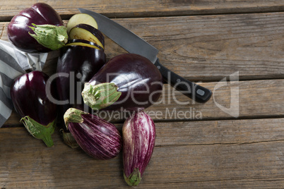 Eggplant with knife on wooden table