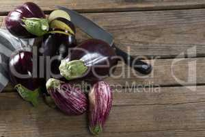 Eggplant with knife on wooden table