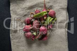 Overhead view of red radishes on burlap