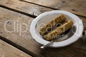 Granola bar in bowl on wooden table