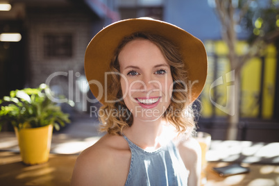 Portrait of smiling beautiful woman wearing hat on sunny day
