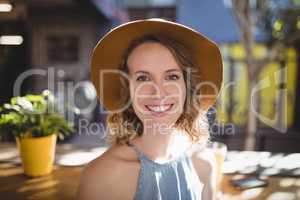 Portrait of smiling beautiful woman wearing hat on sunny day