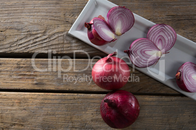 Onions in a tray on a wooden table
