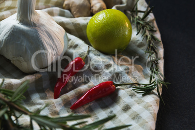 Garlic, red chili pepper, sweet lime and rosemary on table cloth