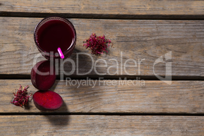 Beetroot juice and slice of beetroot on wooden table