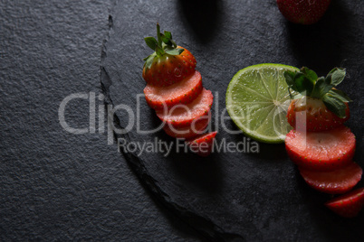 Sliced strawberries and lemon on tray