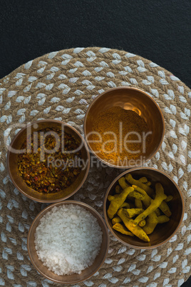 Various spices in bowl on a place mat