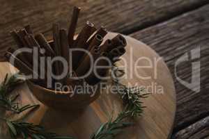 Cinnamon sticks and rosemary on a chopping board