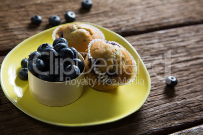 Blueberries and muffins on plate